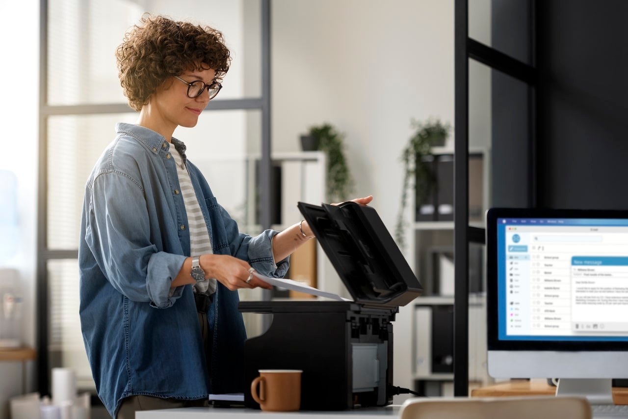 Vue de profil d'une femme dans un environnement professionnel. Elle travaille avec un scanner.