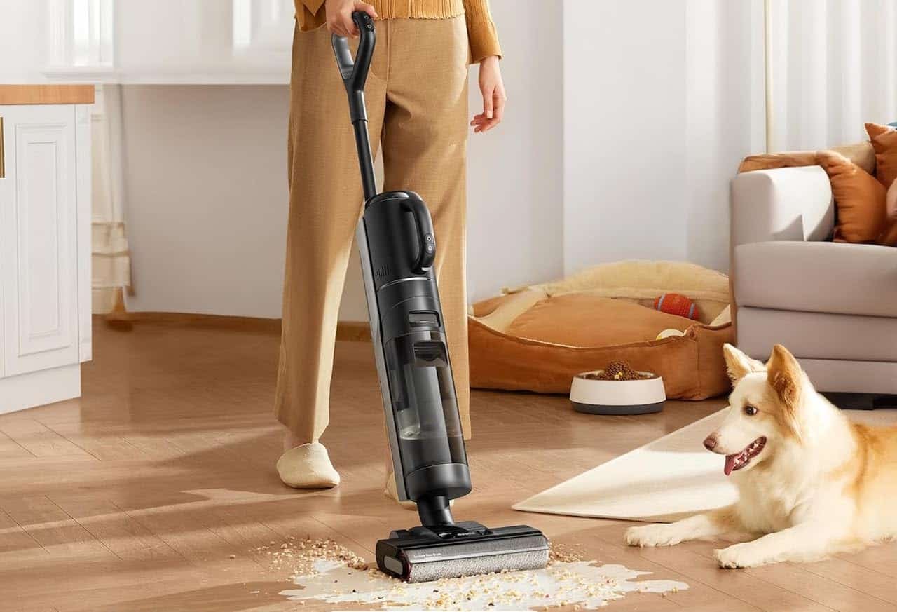 Une femme en train de laver son parquet à l'aide d'un aspirateur laveur de la marque Dreame.