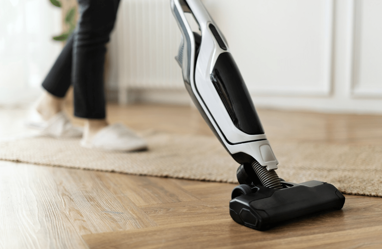 Un aspirateur en gros plan sur un parquet en bois.