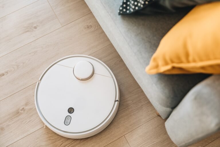 Wireless Robotic vacuum cleaner cleaning a wooden floor in living room