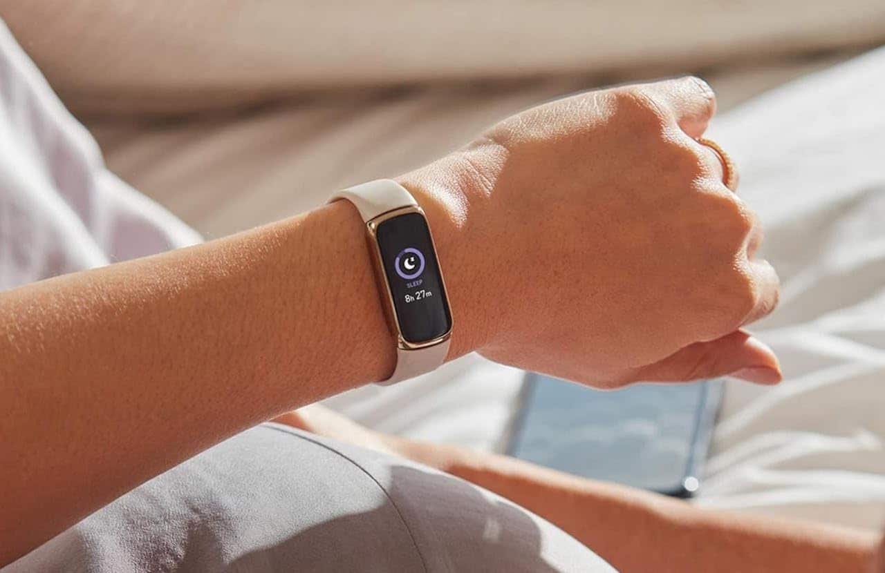 L'avant-bras d'une femme portant un bracelet connecté de la marque Fitbit.