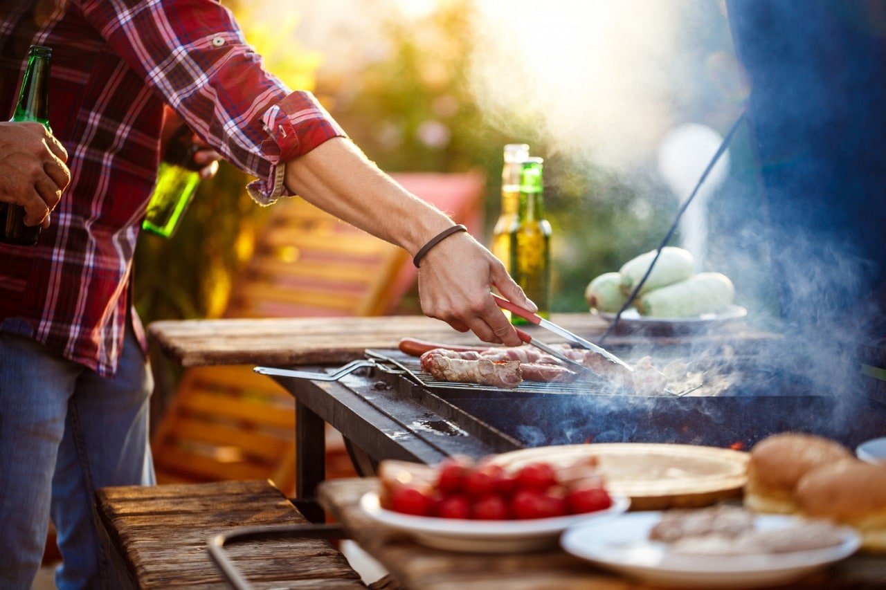Gros plan sur la grille d'un barbecue sur laquelle cuisent des aliments