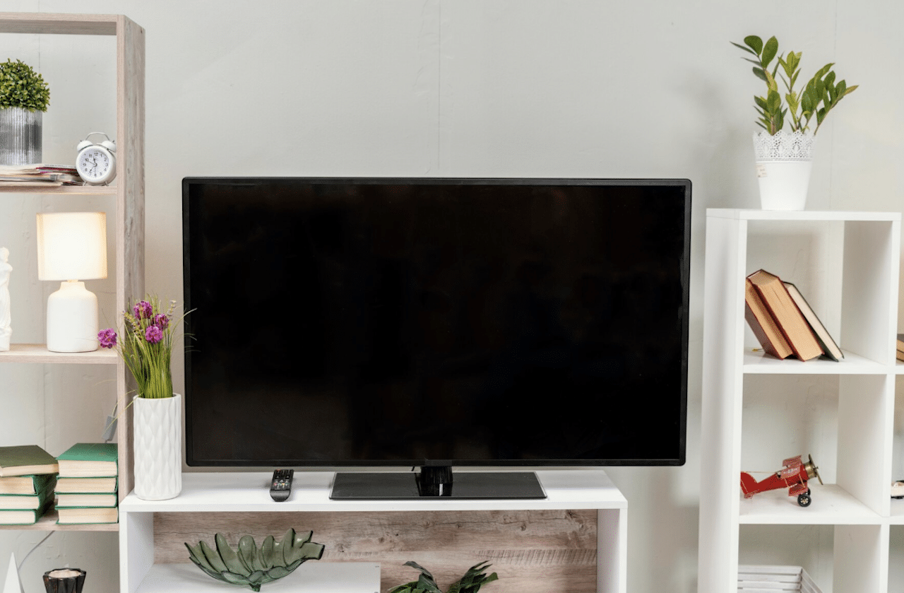 Un téléviseur posé sur un meuble TV blanc dans un salon.