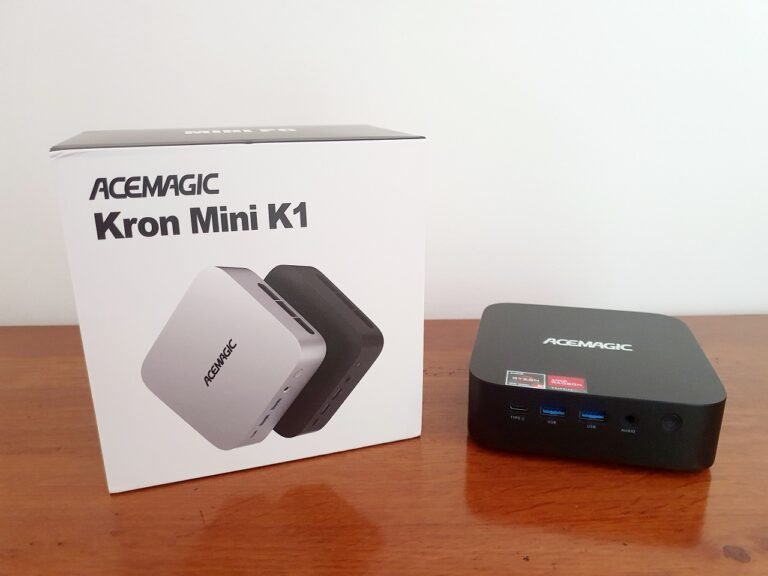 Le mini PC Acemagic Kron Mini K1 posé sur une table à côté de sa boite