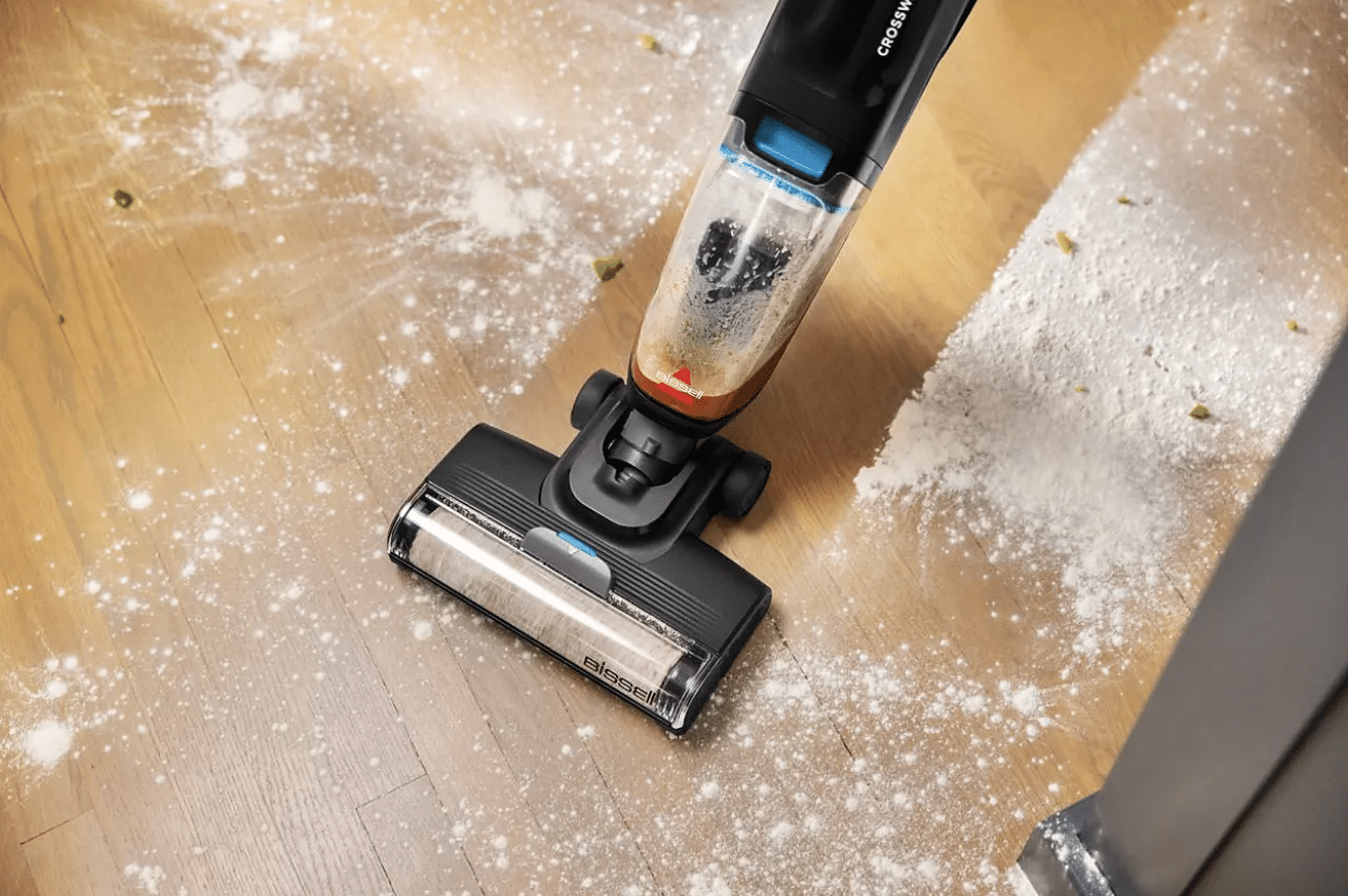 Un aspirateur laveur de la marque Bissell qui nettoie un sol plein de farine.