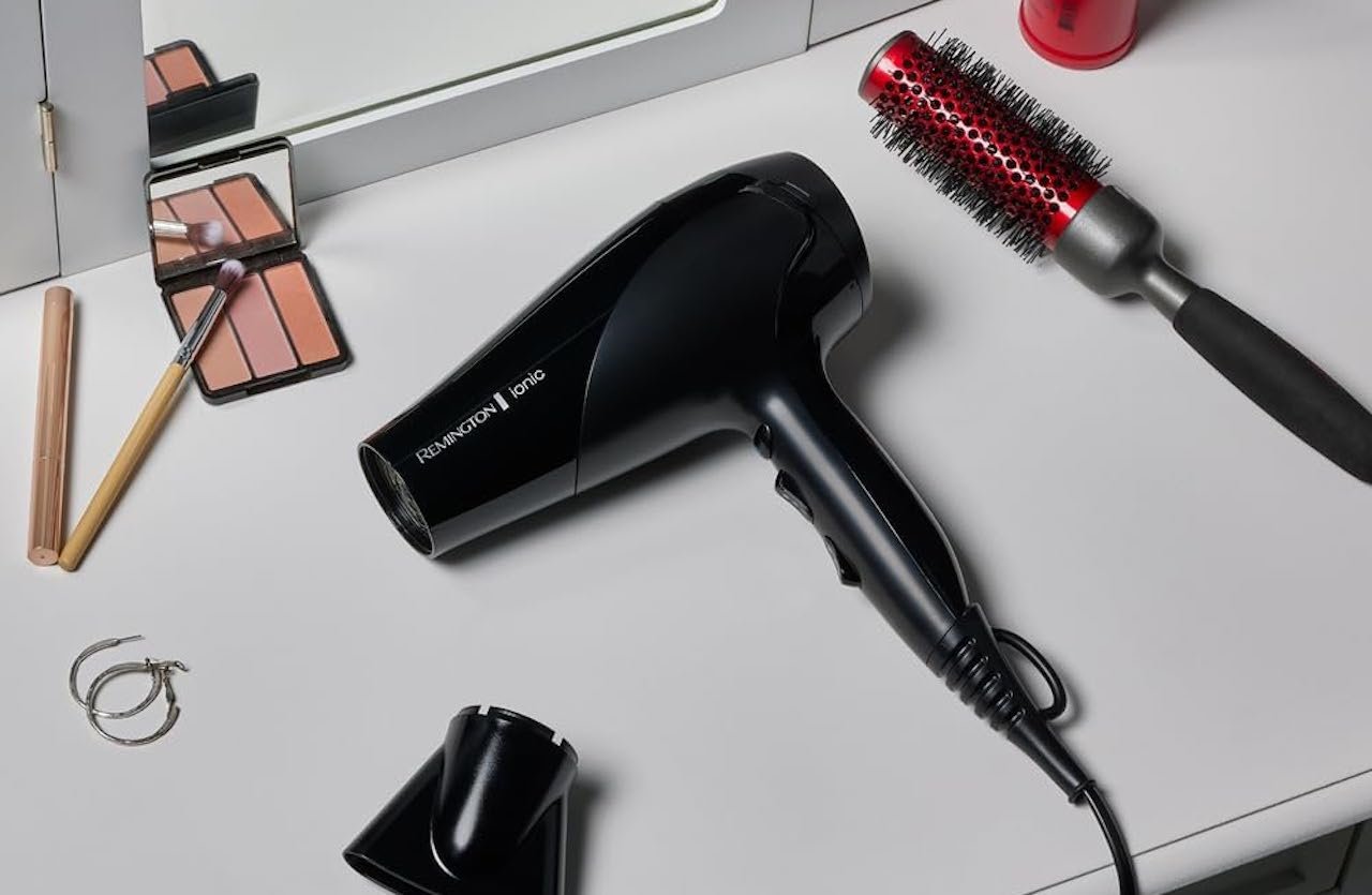 Un coiffeuse avec une brosse, un sèche-cheveux et du maquillage.