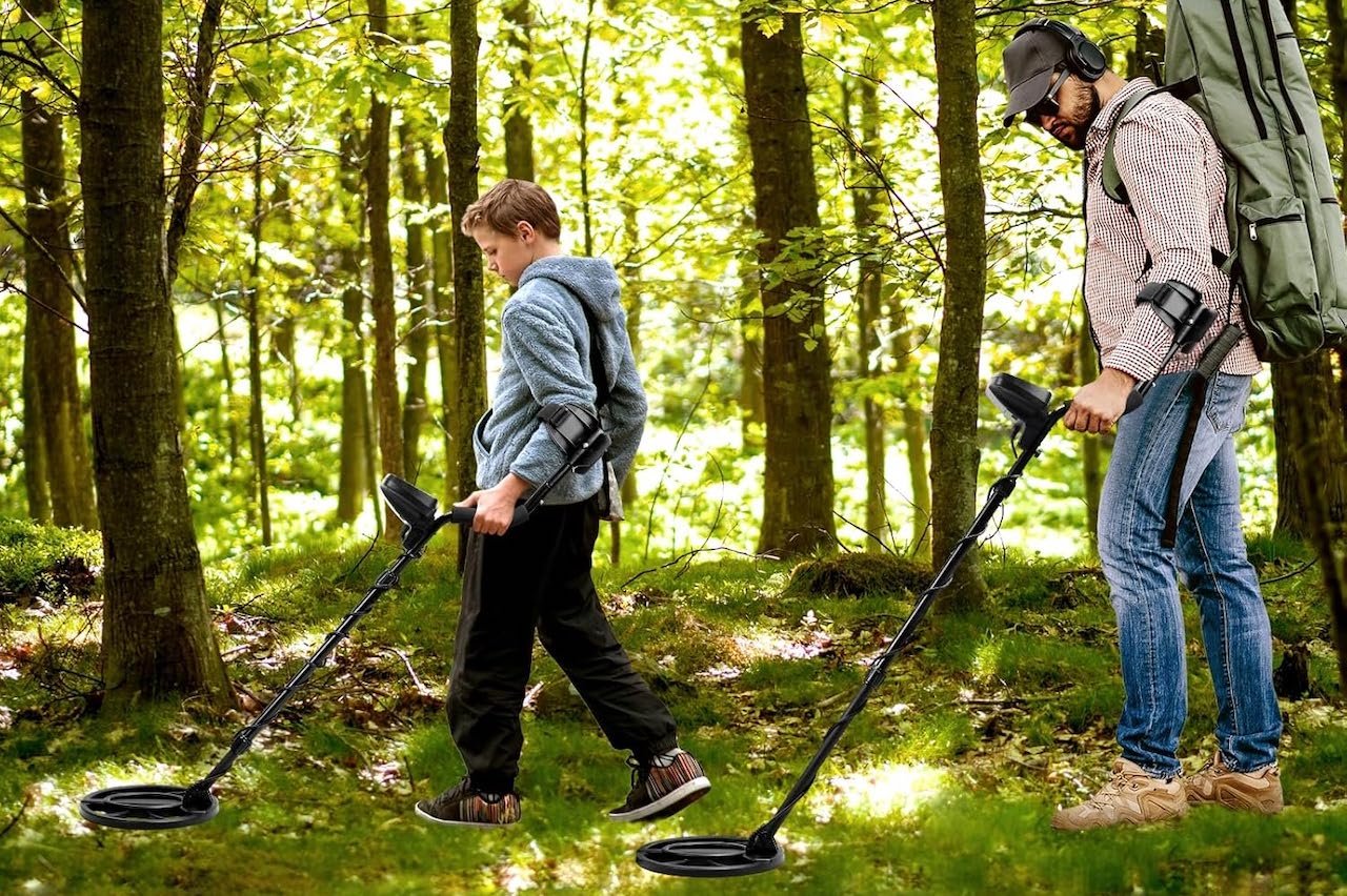 Deux hommes qui utilisent des détecteurs de métaux en forêt.