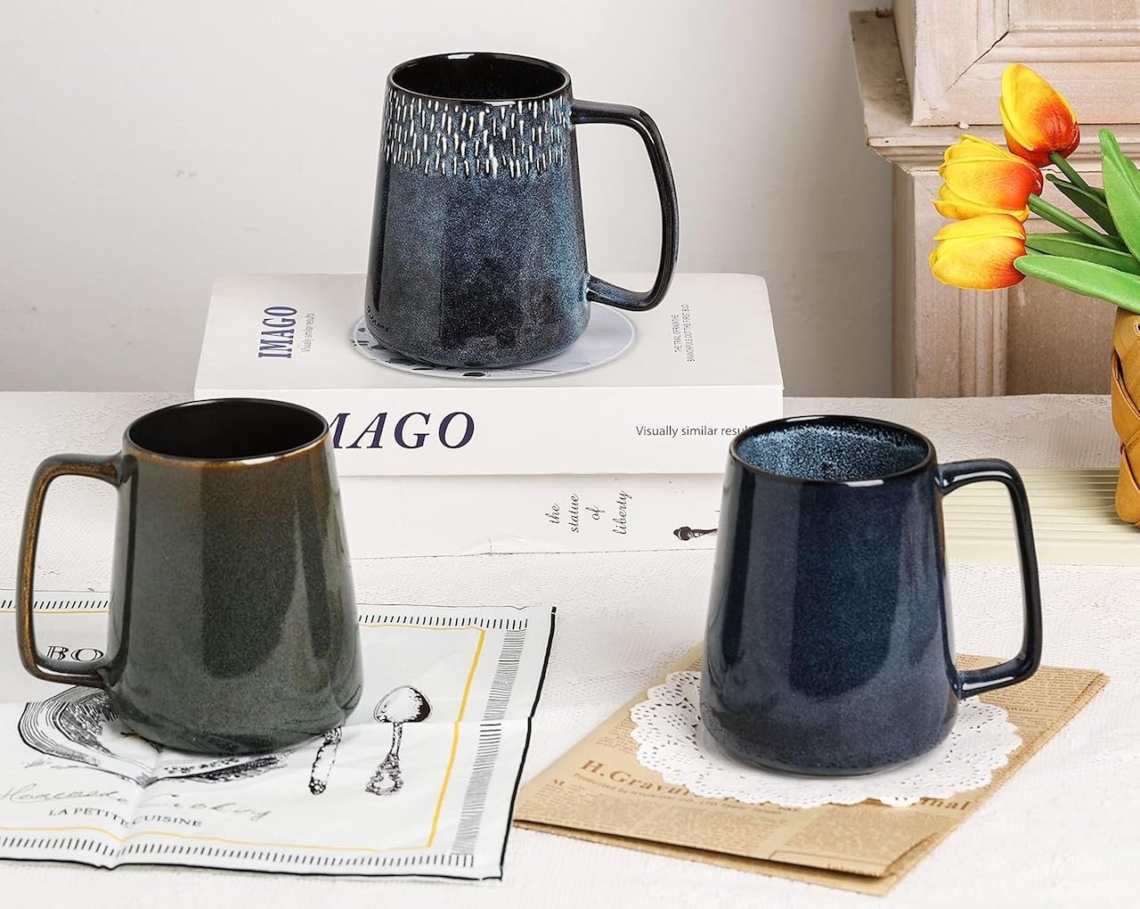 Trois mugs en céramique sur une table.