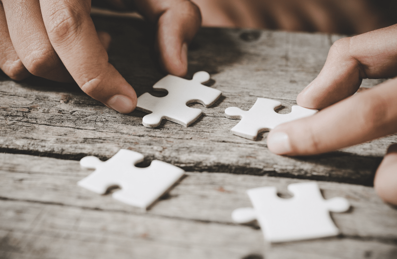 Une personne en train de d'assembler les pièces un puzzle.