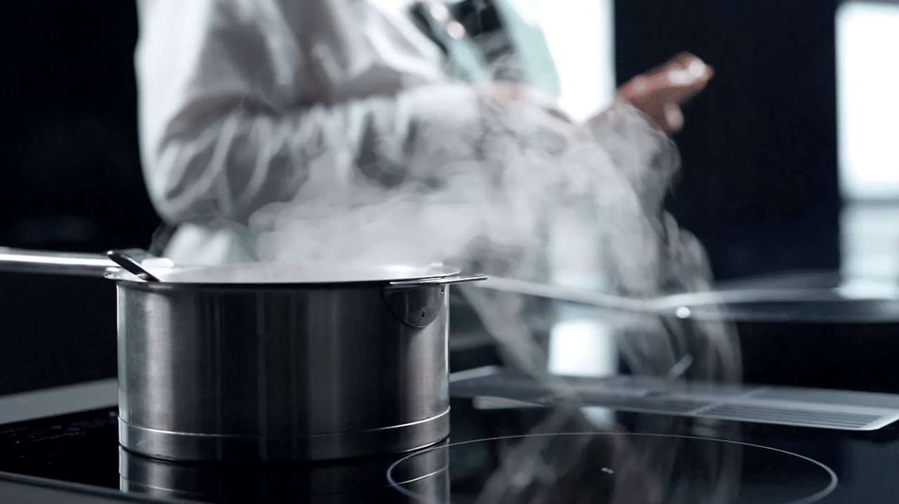 un cuisinier qui utilise une plaque à induction Sauter.