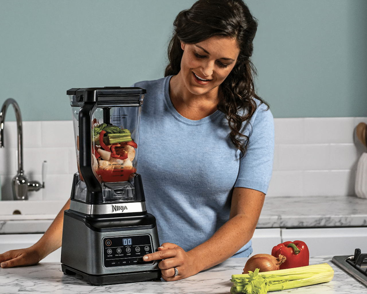 Une femme qui utilise un robot multifonctions de la marque Ninja.