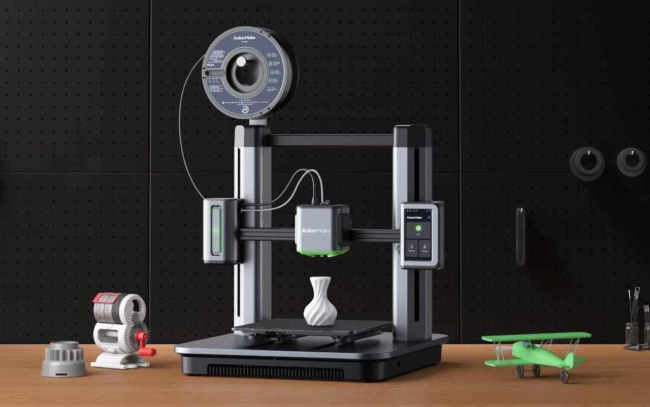 Une imprimante 3D sur une table en bois.