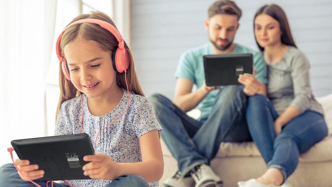 Un couple et leur fille utilisant des lecteurs DVD portables.