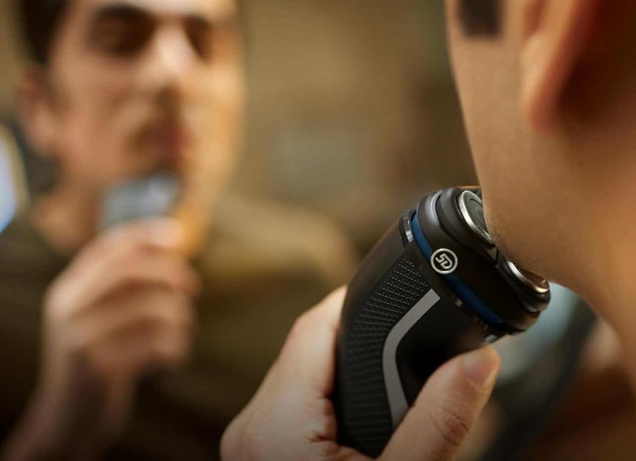 Un homme qui utilise un rasoir électrique.