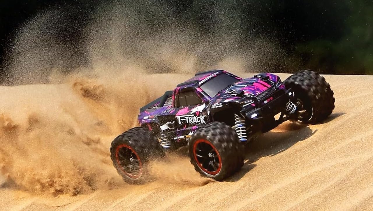 Une voiture télécommandée sur du sable.