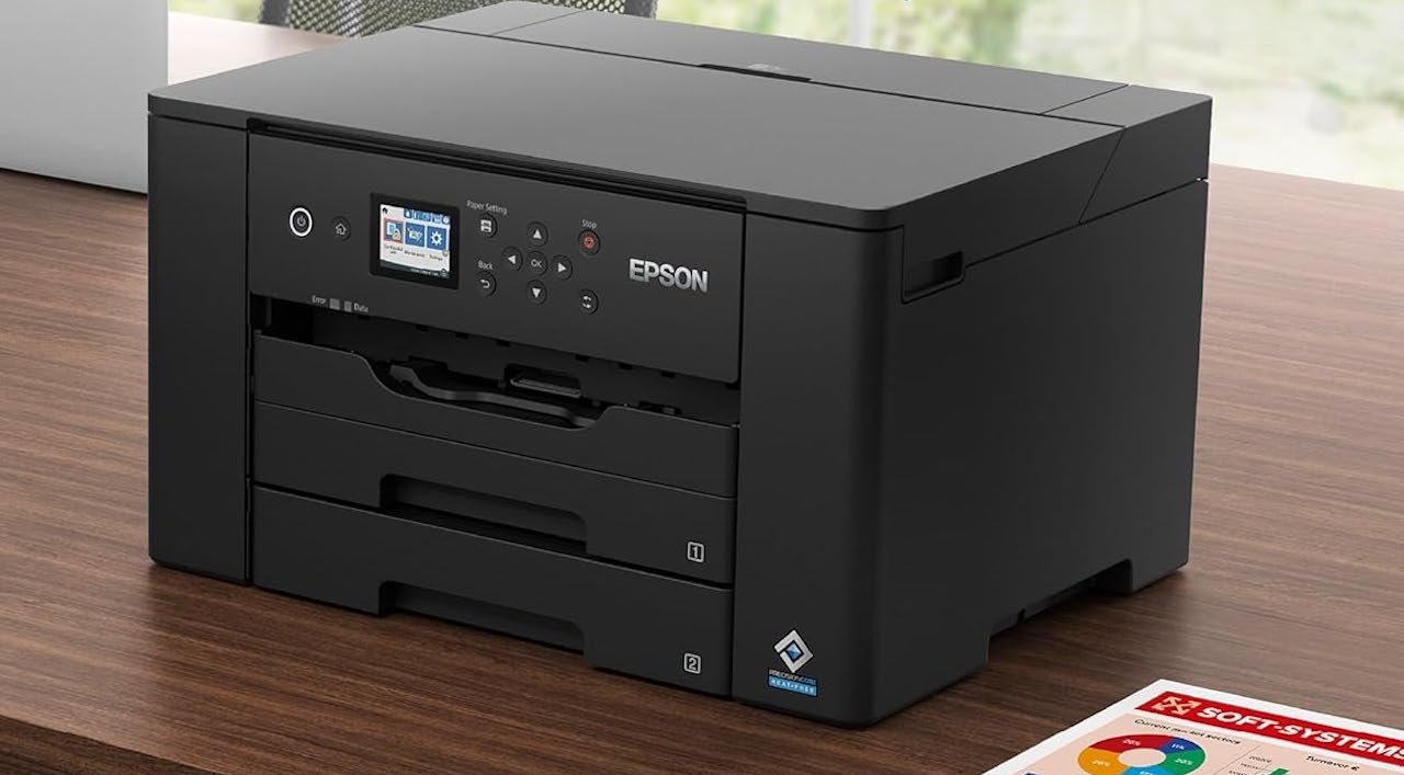 Une imprimante A3 sur un bureau en bois.