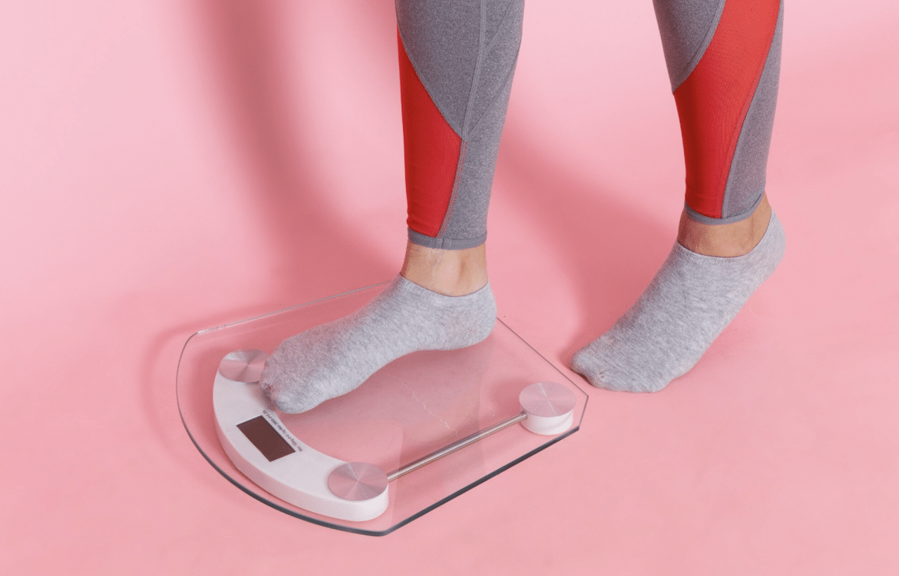 Une femme qui utilise une balance connectée.