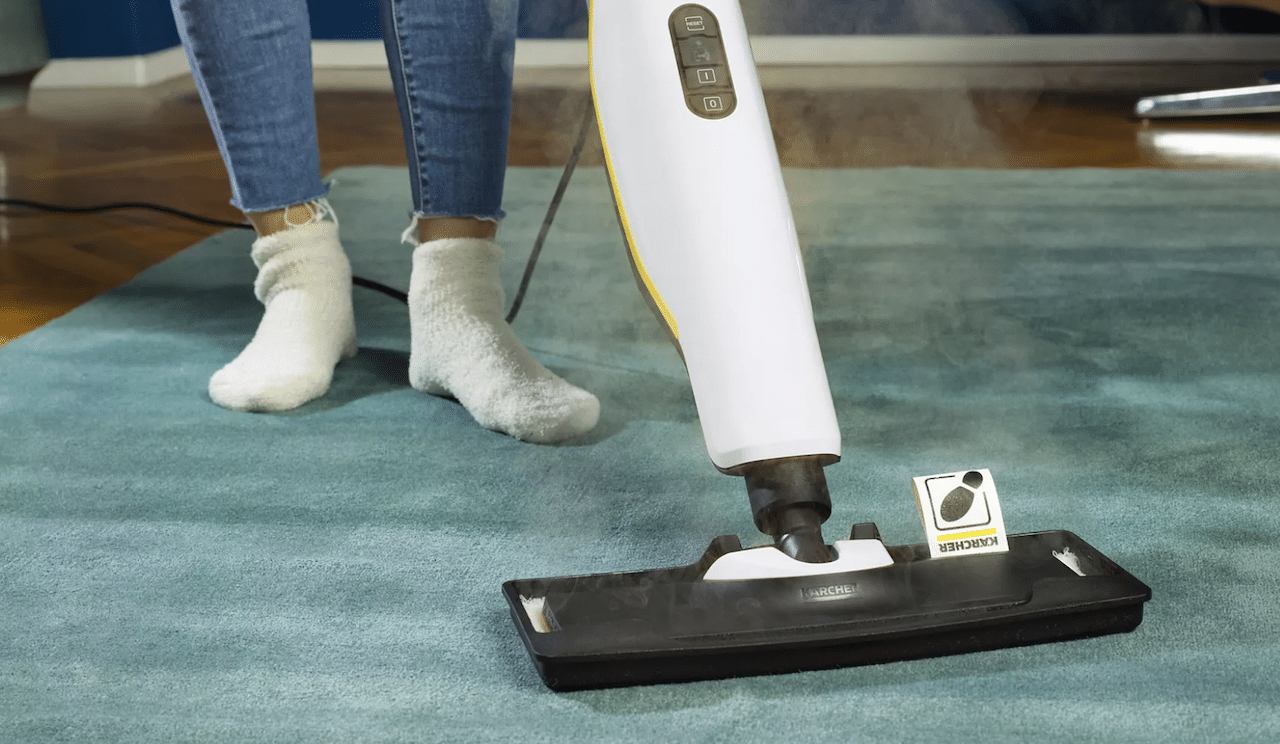 Une femme qui utilise un balai vapeur sur son tapis.