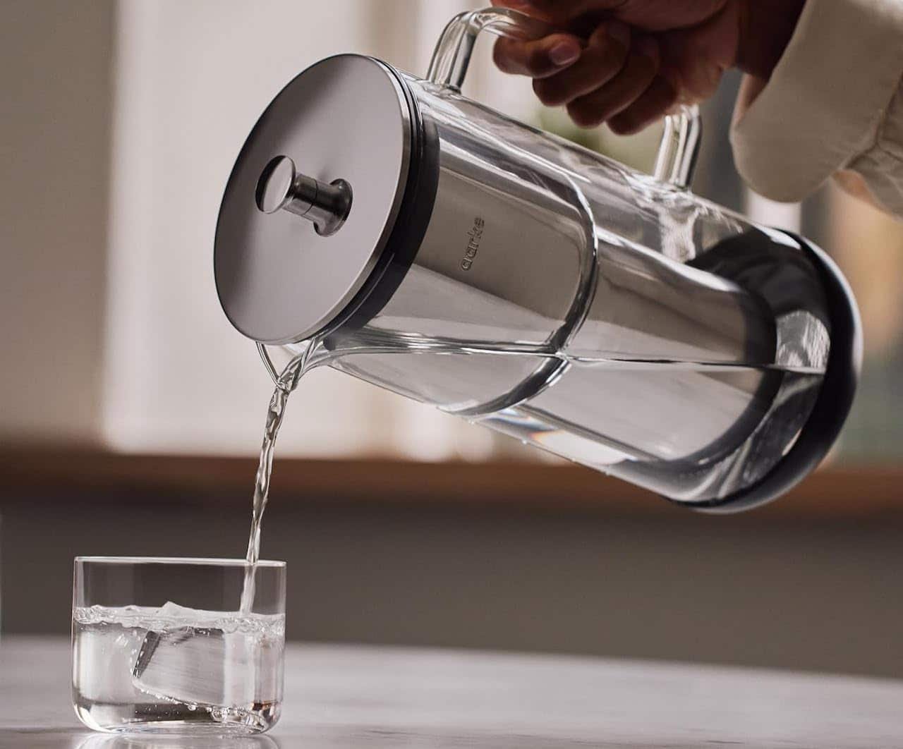 Une femme utilise une carafe filtrante.