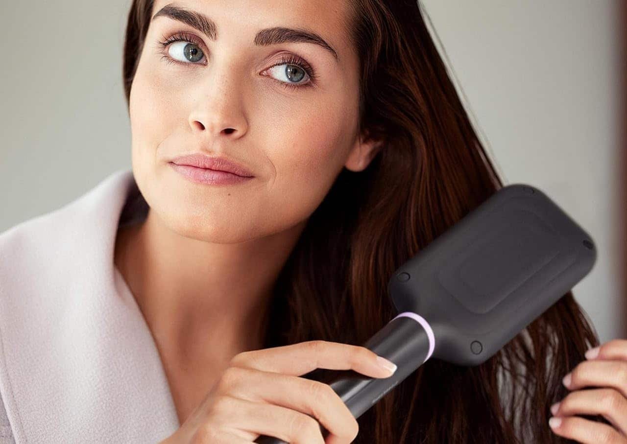 Une femme qui utilise une brosse lissante.
