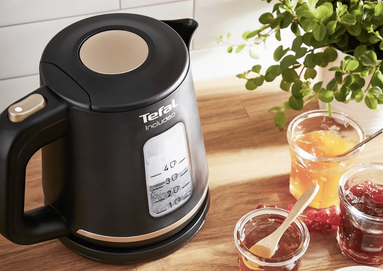 Une bouilloire Tefal posé sur une table en bois.