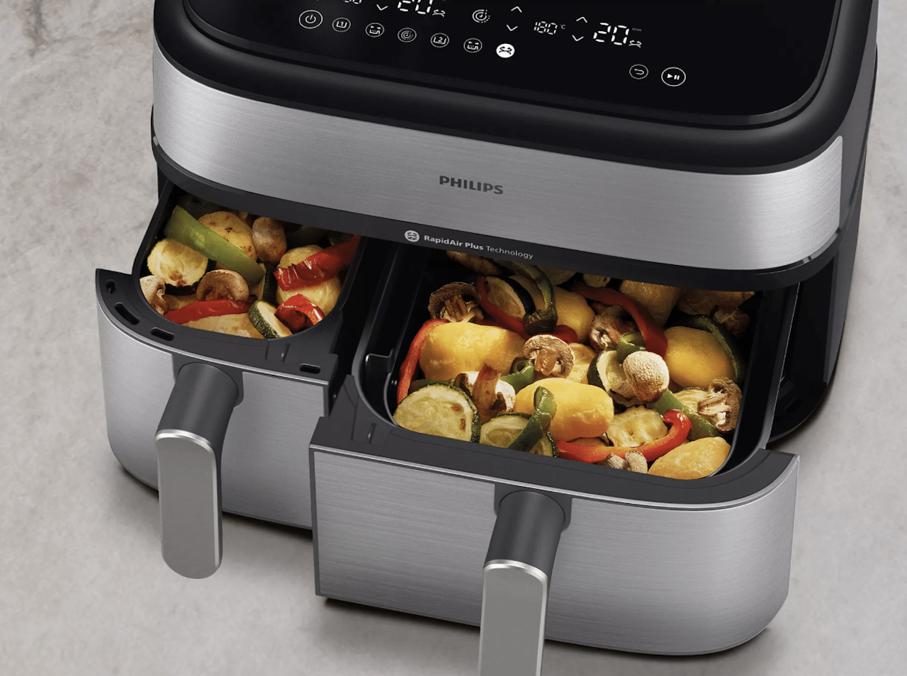 Une friteuse sans huile avec des légumes dans les bacs.