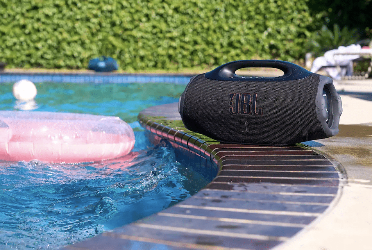 Une enceinte bluetooth portable près d'une piscine.