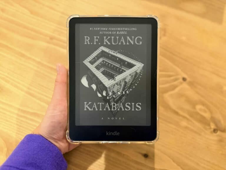 Une liseuse Amazon Kindle Paperwhite tenu dans la main et affichant la couverture d'un ebook